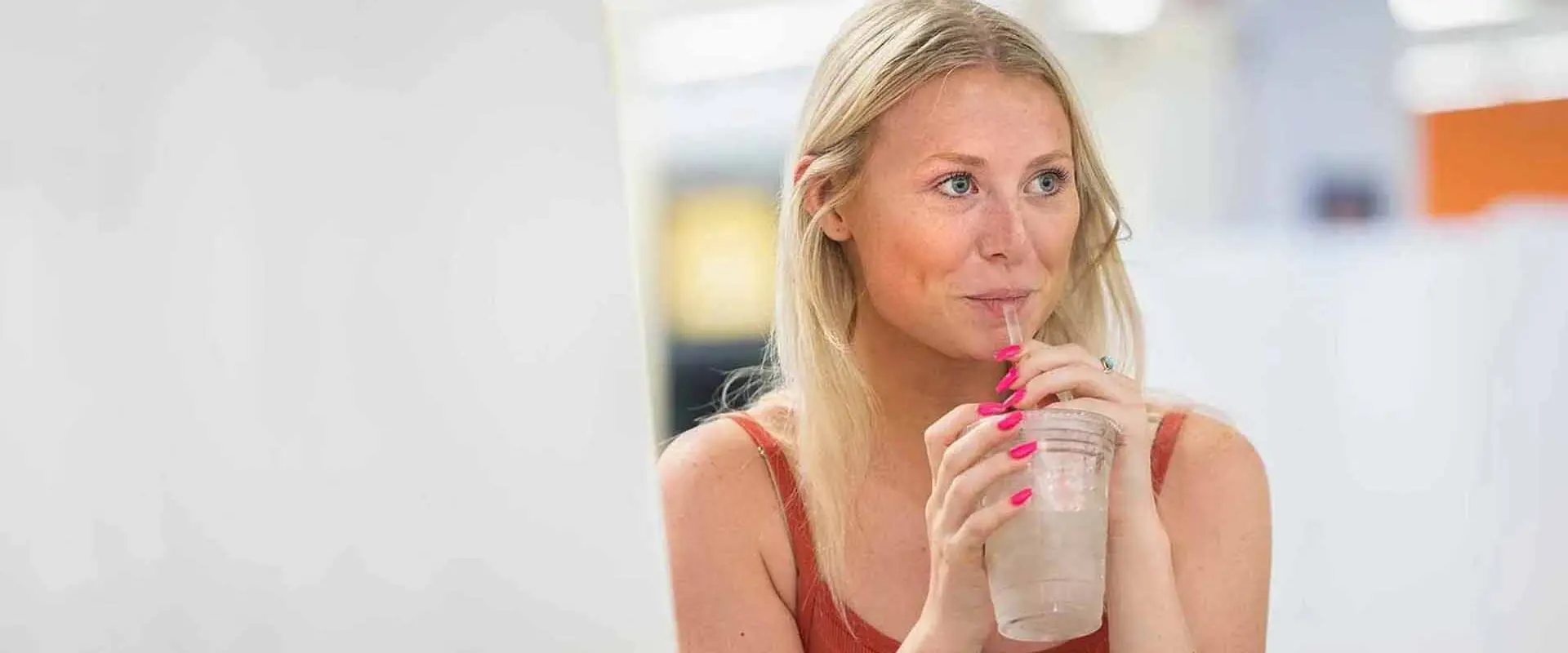 Student sipping iced beverage while looking off into the distance
